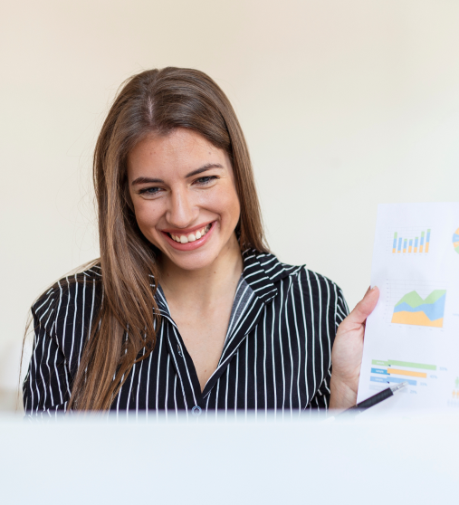 mujer-de-negocios-analizando-datos-usando-la-computadora-mientras-pasa-tiempo-en-la-oficina-hermosa-joven-mujer-profesional-sonriente-en-la-oficina-graficos-y-tablas