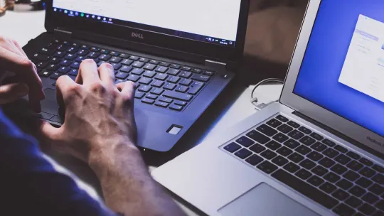 Administrador de sistemas trabajando con dos ordenadores