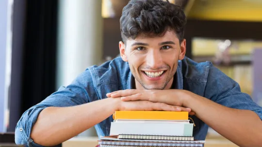 Estudiante de grado superior con libros en la biblioteca.