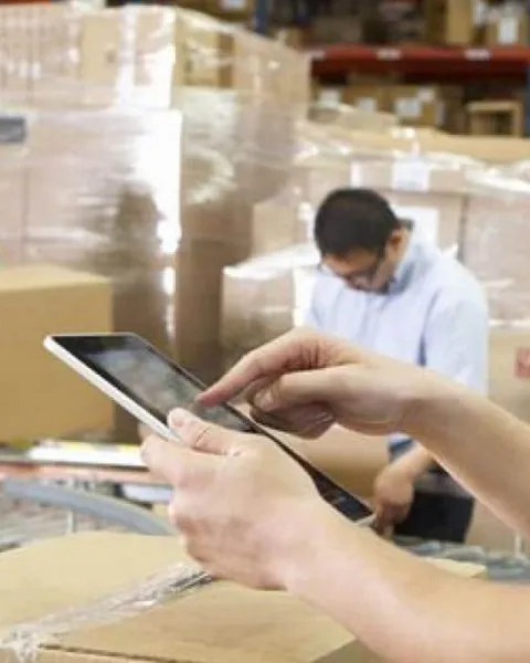 Hombre trabajando con una tablet en un almacén