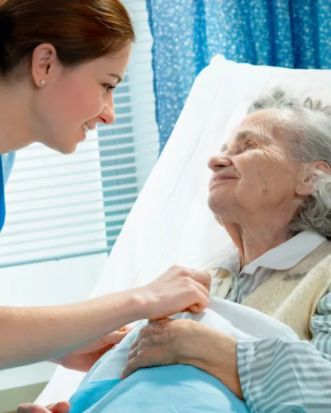 Auxiliar de enfermería cuidando señora con diabetes en el hospital