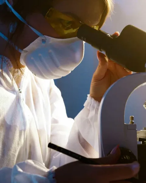 Hombre trabajando con un microscopio en un laboratorio químico
