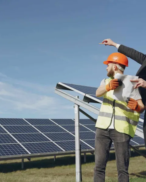 Dos hombres en un campo solar analizan la situación de la instalación de placas solares.