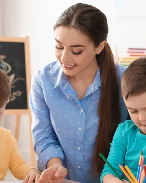 Profesora pintando con sus alumnos escolares en clase