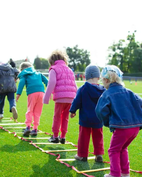 Niños jugando al aire libre, divirtiéndose y haciendo actividad física.