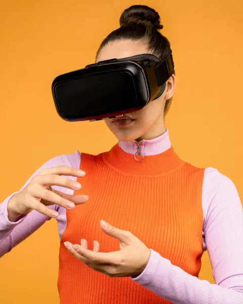 Una mujer con gafas de realidad virtual interactúa en el metaverso.