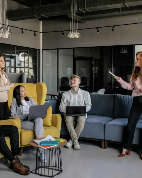 Mujer enseña a un grupo de adultos un diagrama en un lienzo.